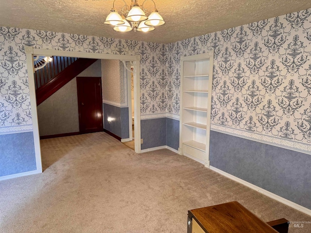 263 Whitman St, Albion, ID 83311 - carpeted empty room with baseboards, a textured ceiling, wallpapered walls, and a notable chandelier