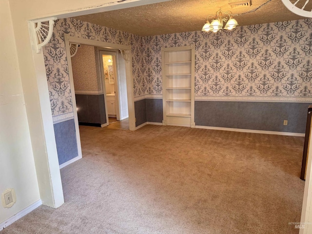 263 Whitman St, Albion, ID 83311 - spare room featuring wallpapered walls, a textured ceiling, carpet, and wainscoting