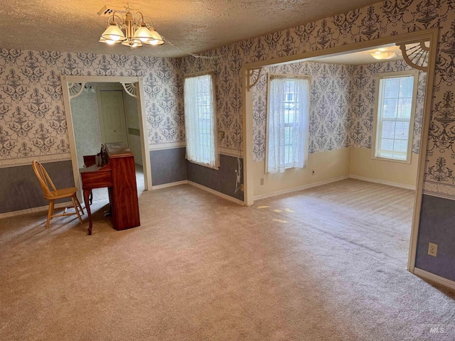 263 Whitman St, Albion, ID 83311 - carpeted dining room with a notable chandelier, a textured ceiling, wainscoting, baseboards, and wallpapered walls
