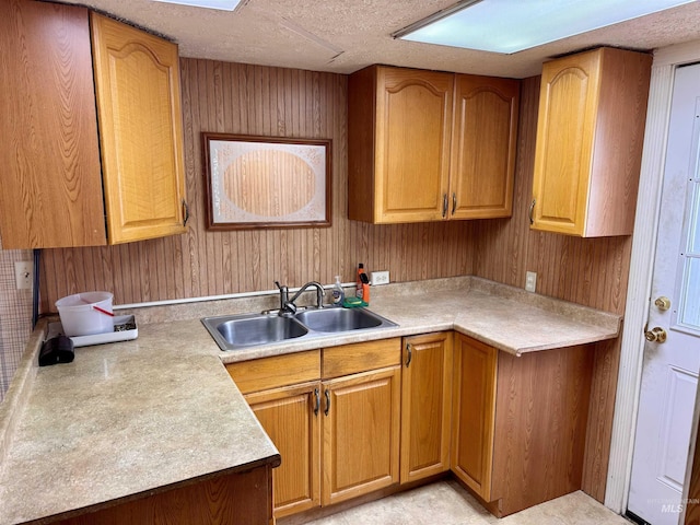 263 Whitman St, Albion, ID 83311 - kitchen featuring light countertops, a sink, wooden walls, a textured ceiling, and brown cabinets