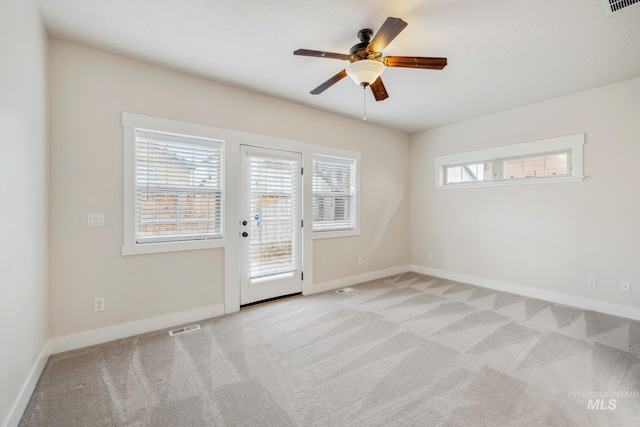 unfurnished room featuring plenty of natural light, baseboards, a ceiling fan, and light colored carpet