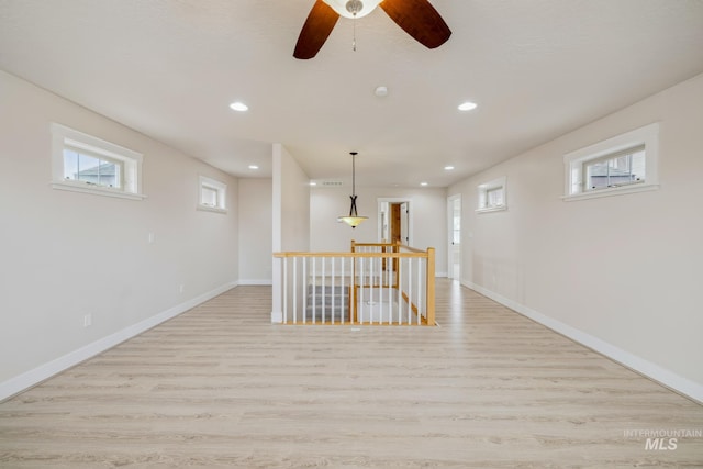 interior space with a wealth of natural light, light wood-type flooring, baseboards, and recessed lighting