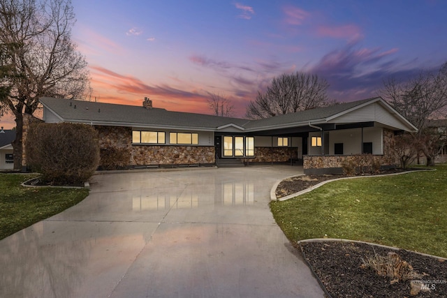 single story home featuring a carport and a yard