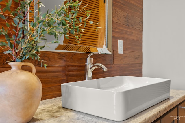 bathroom featuring sink and wood walls