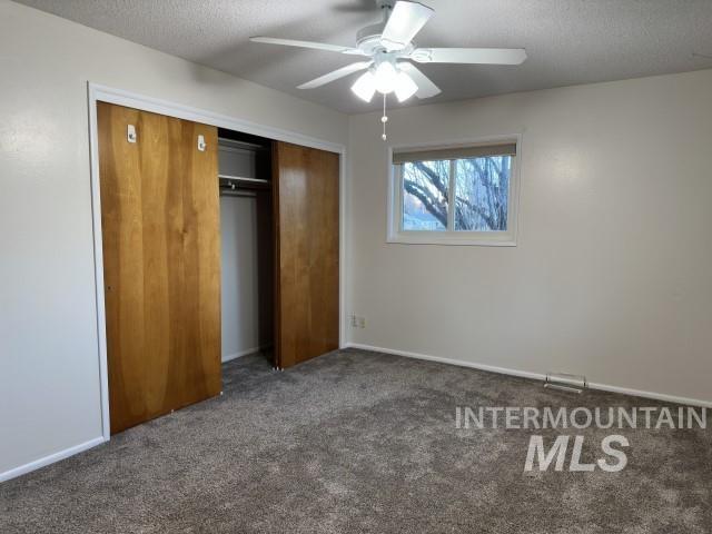 995 E 15th N, Mountain Home, ID 83647 - unfurnished bedroom featuring a textured ceiling, baseboards, carpet, and a closet