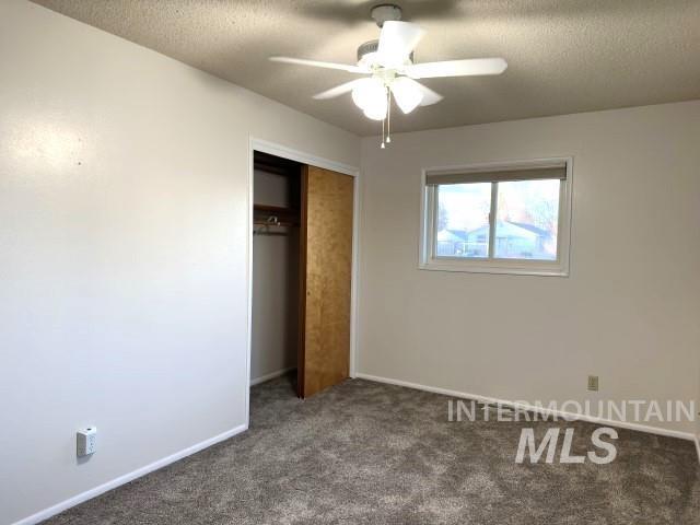 995 E 15th N, Mountain Home, ID 83647 - unfurnished bedroom with a closet, carpet flooring, a textured ceiling, and baseboards