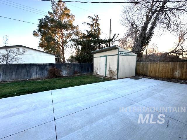 995 E 15th N, Mountain Home, ID 83647 - view of patio featuring a fenced backyard, a storage unit, and an outdoor structure