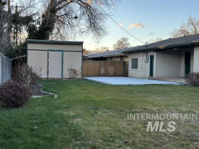 995 E 15th N, Mountain Home, ID 83647 - view of yard featuring a patio, an outdoor structure, fence, and a storage unit