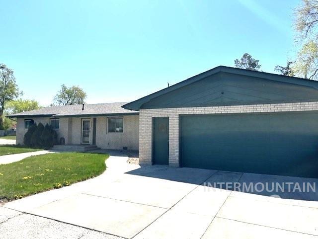 995 E 15th N, Mountain Home, ID 83647 - single story home featuring brick siding, an attached garage, driveway, and a front yard