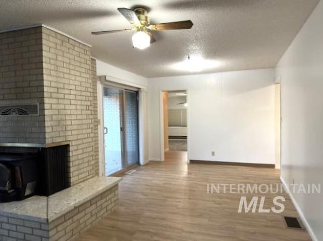 995 E 15th N, Mountain Home, ID 83647 - unfurnished living room with visible vents, a textured ceiling, and wood finished floors