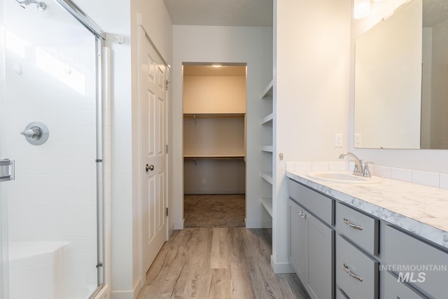 bathroom featuring hardwood / wood-style flooring, vanity, and a shower with shower door