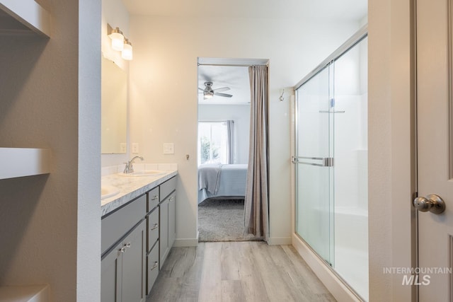 bathroom featuring hardwood / wood-style flooring, vanity, and a shower with door