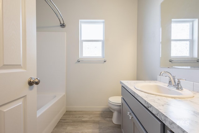 full bathroom featuring plenty of natural light, toilet, hardwood / wood-style floors, and vanity