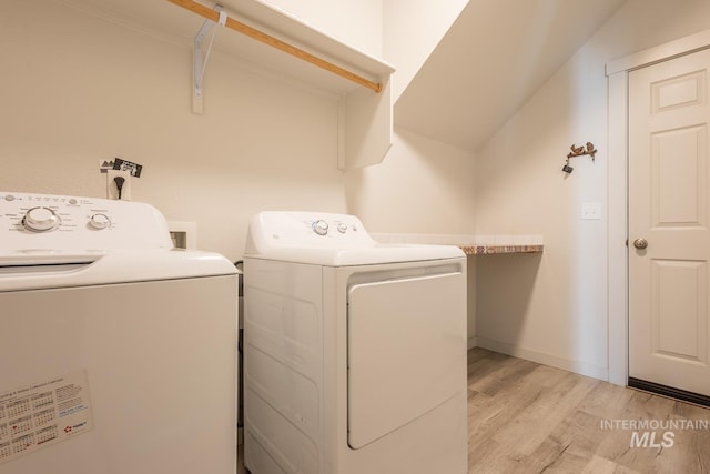 washroom featuring washing machine and clothes dryer and light wood-type flooring