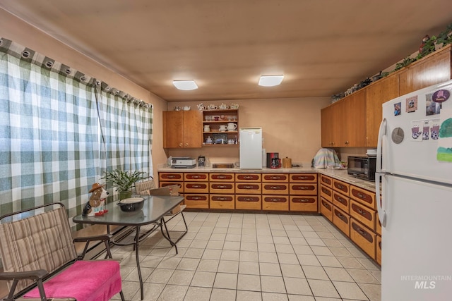 kitchen featuring white fridge and light tile patterned floors