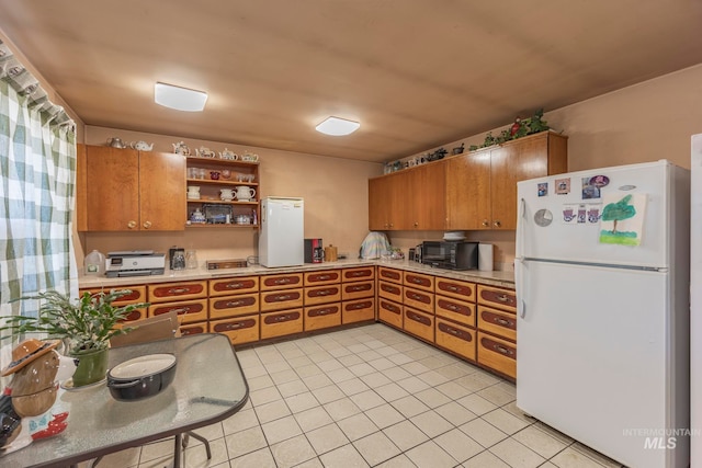 kitchen with white refrigerator and light tile patterned floors