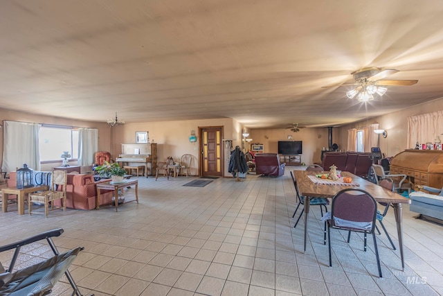 tiled dining area featuring ceiling fan with notable chandelier