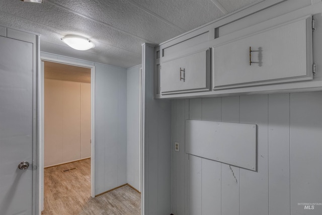 laundry room featuring visible vents and light wood-style flooring