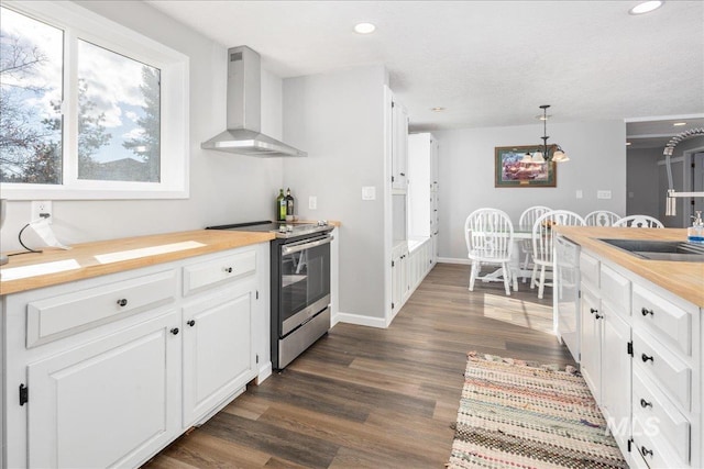 kitchen featuring electric range, white cabinetry, dark wood-type flooring, and wall chimney range hood