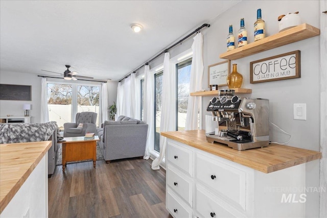 kitchen featuring a healthy amount of sunlight, wooden counters, and white cabinetry