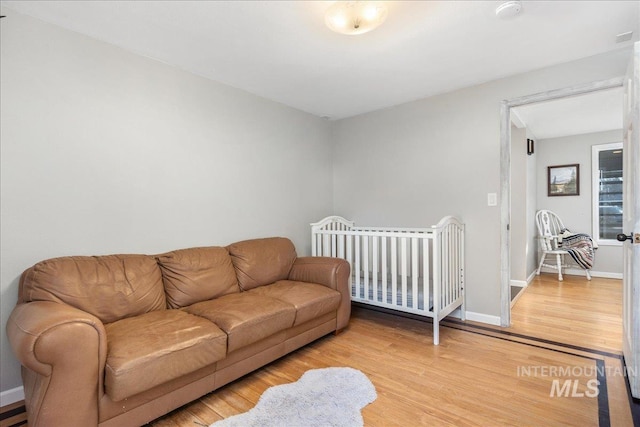 living area with light wood-type flooring and baseboards