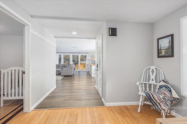 hallway with baseboards and wood-type flooring