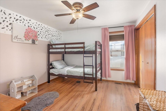 bedroom with visible vents, light wood-style flooring, and a ceiling fan