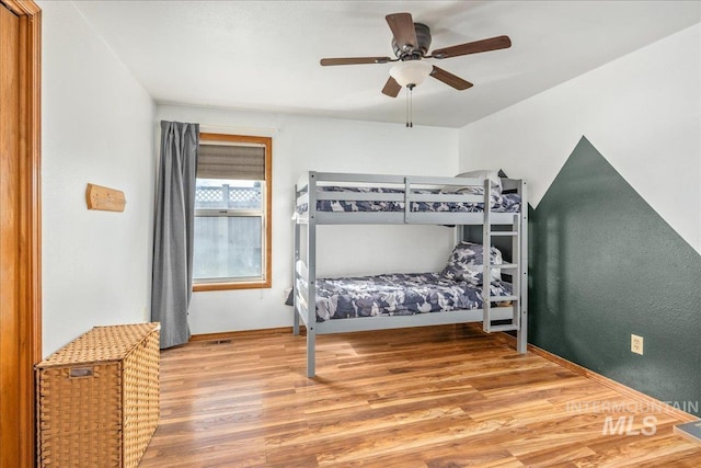 bedroom featuring wood finished floors, visible vents, and ceiling fan