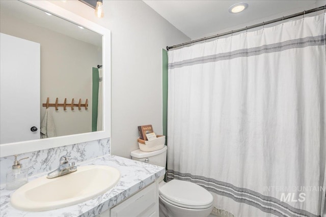 bathroom featuring vanity, curtained shower, and toilet