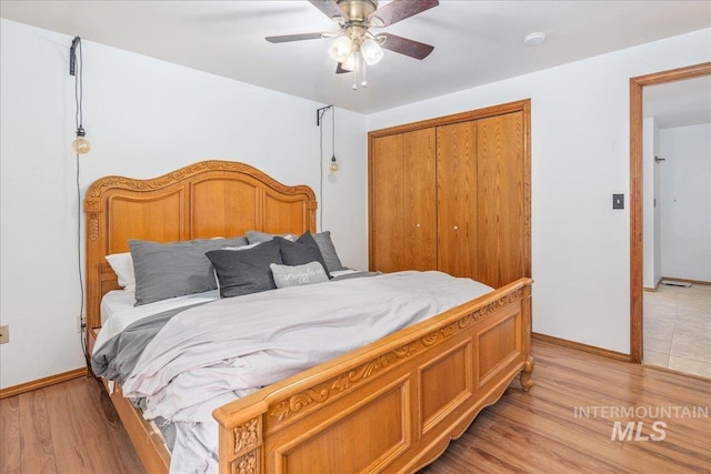 bedroom featuring a closet, light wood-style flooring, baseboards, and ceiling fan