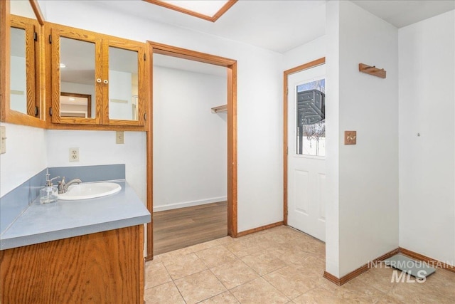 bathroom with tile patterned floors, baseboards, and vanity