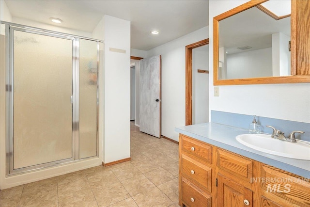 bathroom featuring recessed lighting, a stall shower, vanity, and baseboards