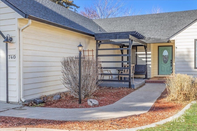 entrance to property featuring roof with shingles