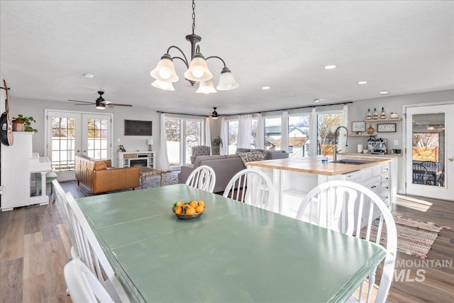 dining room with recessed lighting, a fireplace, french doors, dark wood-style floors, and a textured ceiling