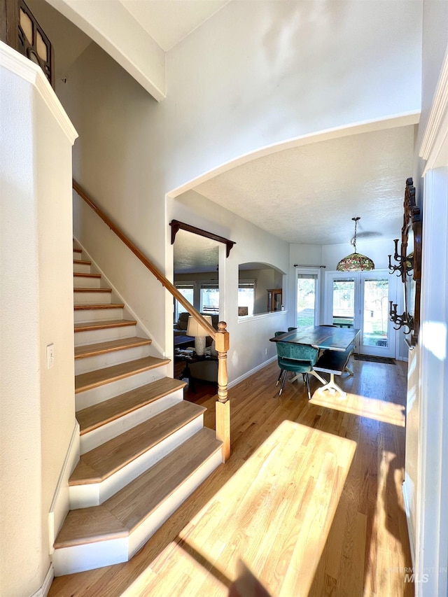 stairs featuring french doors and hardwood / wood-style floors