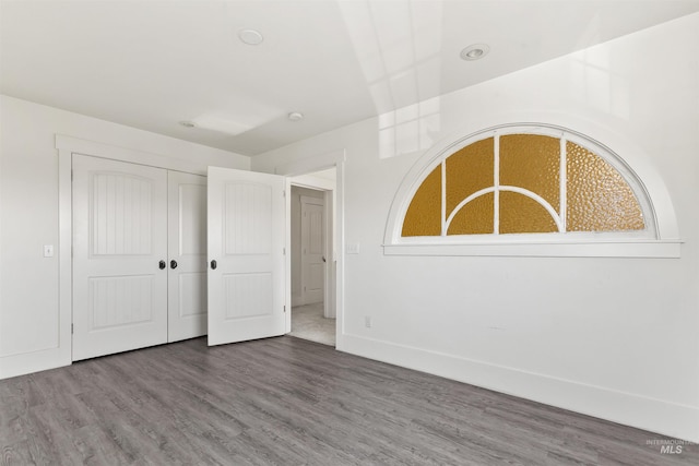 unfurnished bedroom with hardwood / wood-style flooring and a closet