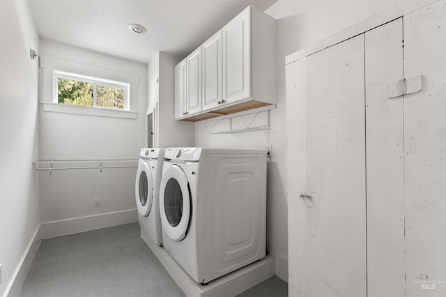 laundry area with washing machine and dryer and cabinets