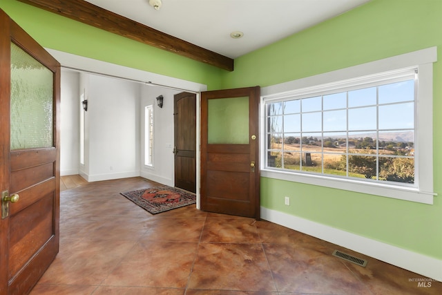 entryway featuring beamed ceiling, tile patterned floors, and a wealth of natural light