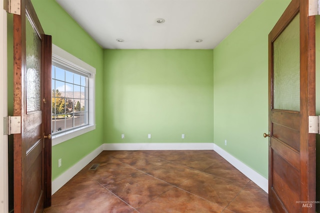 unfurnished room with dark tile patterned floors