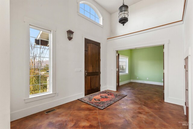 tiled entryway featuring a high ceiling and a healthy amount of sunlight