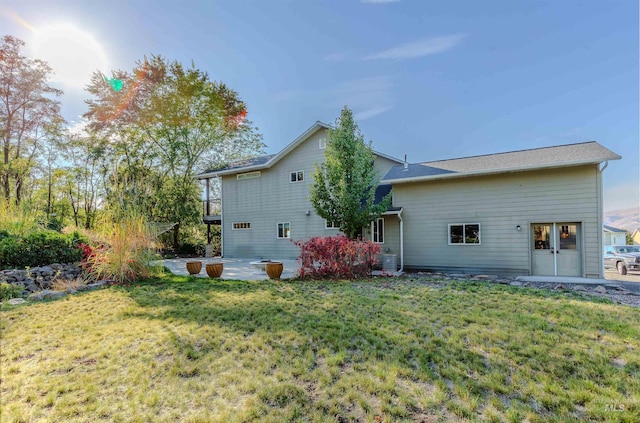 rear view of house with a patio area and a lawn