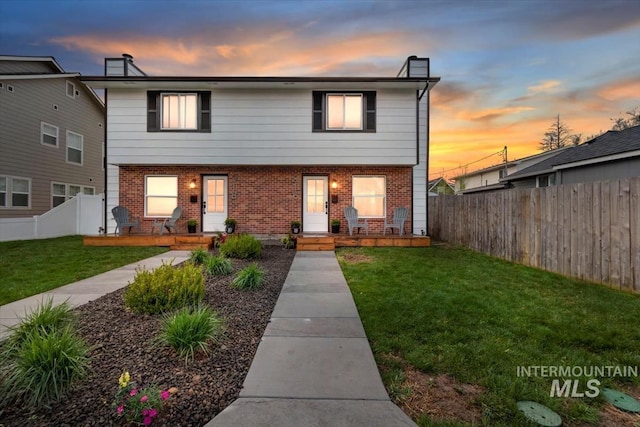 916 N 32nd St, Boise, ID 83702 - view of front of property with a fenced backyard, covered porch, a front lawn, and brick siding
