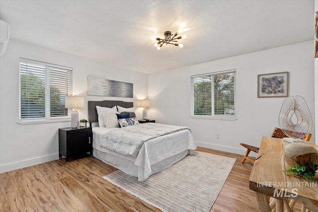 916 N 32nd St, Boise, ID 83702 - bedroom featuring light wood-style floors, an inviting chandelier, baseboards, and an AC wall unit