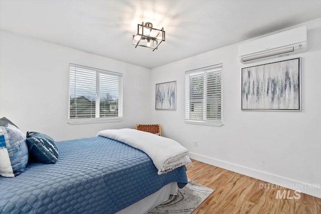 916 N 32nd St, Boise, ID 83702 - bedroom featuring baseboards, an inviting chandelier, wood finished floors, and a wall unit AC