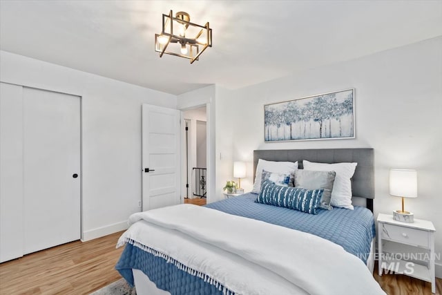 916 N 32nd St, Boise, ID 83702 - bedroom featuring a closet, baseboards, an inviting chandelier, and wood finished floors