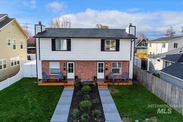 916 N 32nd St, Boise, ID 83702 - view of front of home with a chimney, a fenced backyard, brick siding, a front lawn, and a wooden deck