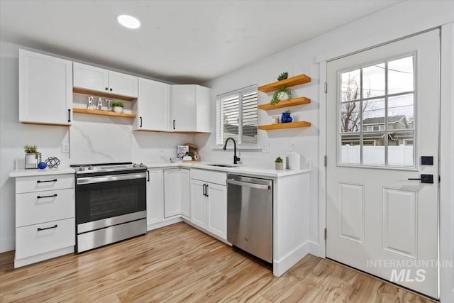 916 N 32nd St, Boise, ID 83702 - kitchen with light countertops, open shelves, light wood-style floors, appliances with stainless steel finishes, and a sink