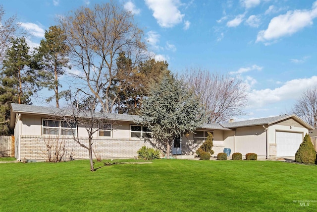 view of front of home featuring brick siding, an attached garage, and a front lawn