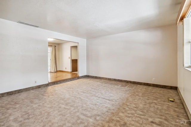 carpeted empty room featuring visible vents and baseboards