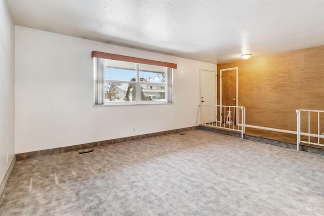 carpeted spare room featuring visible vents and baseboards